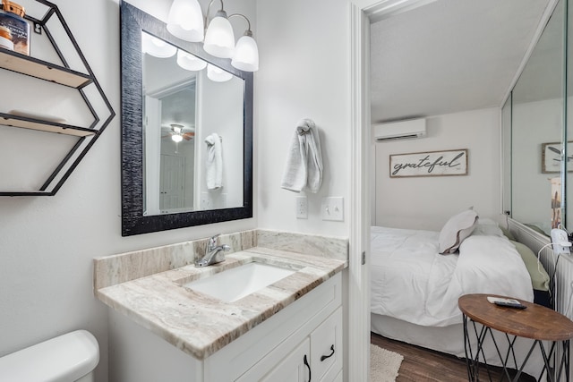 16 Court Dr, Destin, FL 32541 - bathroom with an AC wall unit, connected bathroom, wood finished floors, vanity, and toilet