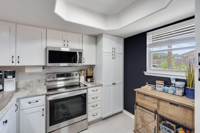 16 Court Dr, Destin, FL 32541 - kitchen featuring stainless steel appliances, white cabinetry, light wood-type flooring, and light stone countertops
