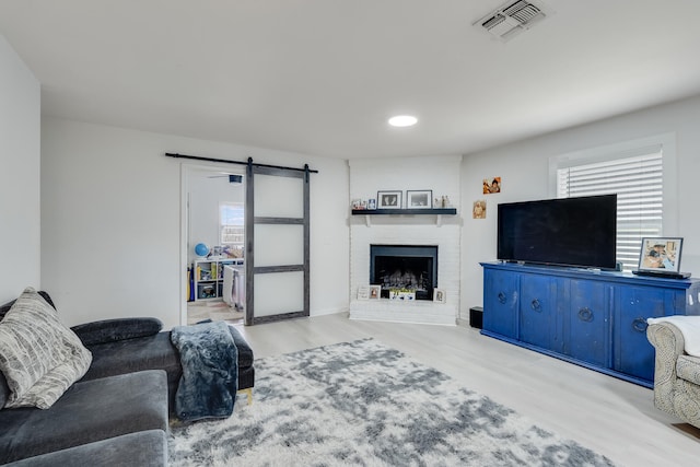 16 Court Dr, Destin, FL 32541 - living area featuring a barn door, wood finished floors, plenty of natural light, and a fireplace
