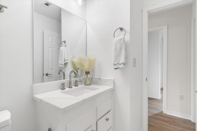 2932 Stillwell Blvd, Crestview, FL 32539 - bathroom featuring vanity, wood finished floors, toilet, and baseboards