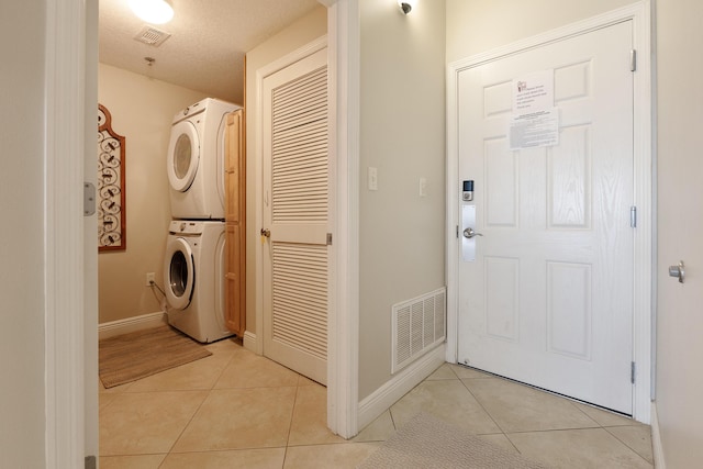 112 Seascape Dr Unit 1807, Miramar Beach, FL 32550 - laundry area with stacked washing machine and dryer, light tile patterned flooring, and baseboards