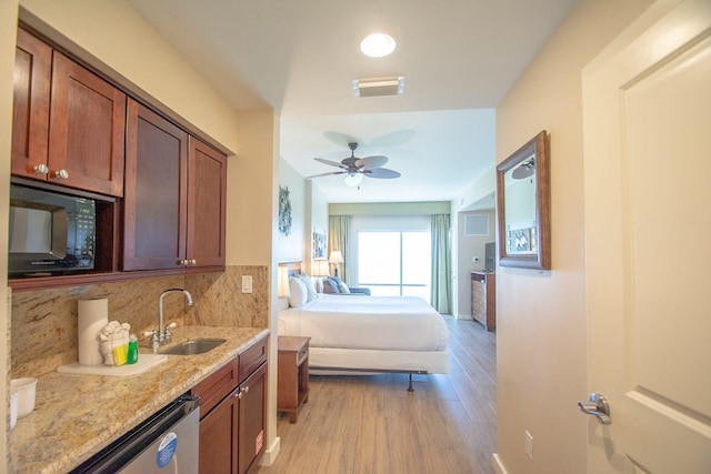 5000 S Sandestin Blvd Unit 7906, Miramar Beach, FL 32550 - kitchen with black microwave, light wood finished floors, a sink, backsplash, and light stone counters