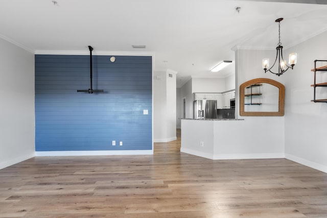 4507 Furling Ln Unit 302, Destin, FL 32541 - unfurnished living room featuring ornamental molding, light wood-style floors, a chandelier, and baseboards