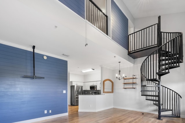 4507 Furling Ln Unit 302, Destin, FL 32541 - unfurnished living room with stairway, light wood-style flooring, baseboards, and a chandelier