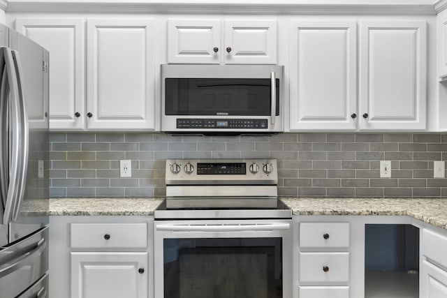 4507 Furling Ln Unit 302, Destin, FL 32541 - kitchen with appliances with stainless steel finishes, white cabinetry, and backsplash