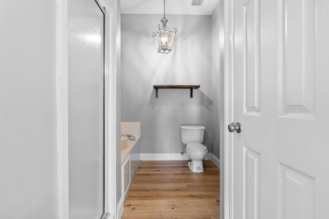 4507 Furling Ln Unit 302, Destin, FL 32541 - full bathroom featuring toilet, a bath, a shower stall, wood finished floors, and baseboards