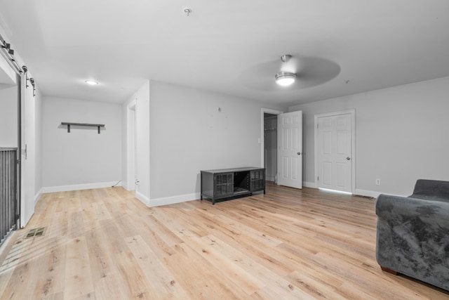 4507 Furling Ln Unit 302, Destin, FL 32541 - living area with a barn door, a ceiling fan, light wood-style flooring, and baseboards