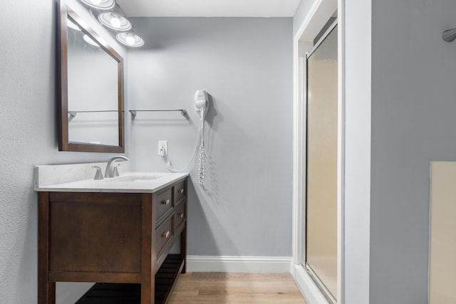4507 Furling Ln Unit 302, Destin, FL 32541 - full bathroom with vanity, wood finished floors, a stall shower, and baseboards