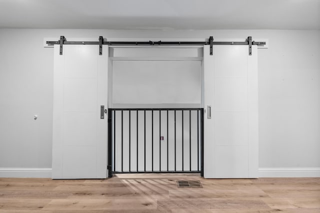 4507 Furling Ln Unit 302, Destin, FL 32541 - detailed view of a barn door, baseboards, and wood finished floors
