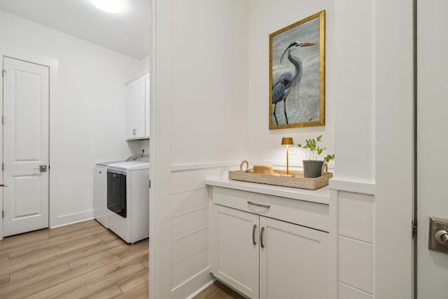282 W Lafayette Rd, Inlet Beach, FL 32461 - washroom with separate washer and dryer, light wood-type flooring, and cabinet space