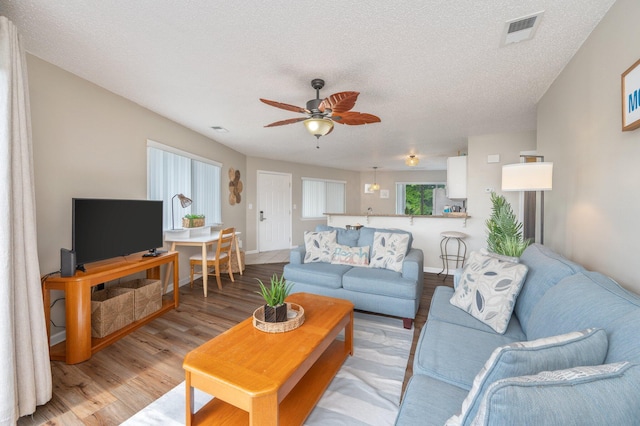285 Payne St Unit 23B, Miramar Beach, FL 32550 - living room with light wood finished floors, a ceiling fan, a textured ceiling, and baseboards