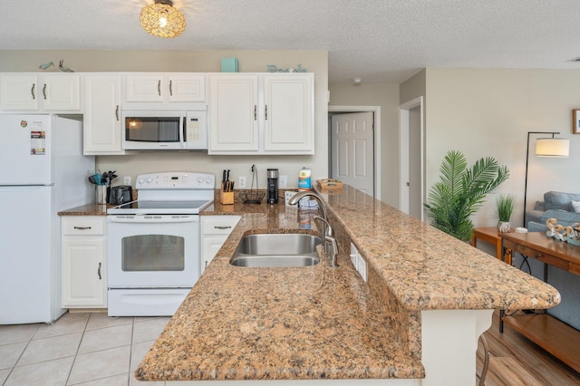 285 Payne St Unit 23B, Miramar Beach, FL 32550 - kitchen with white appliances, a sink, white cabinetry, a peninsula, and light tile patterned floors