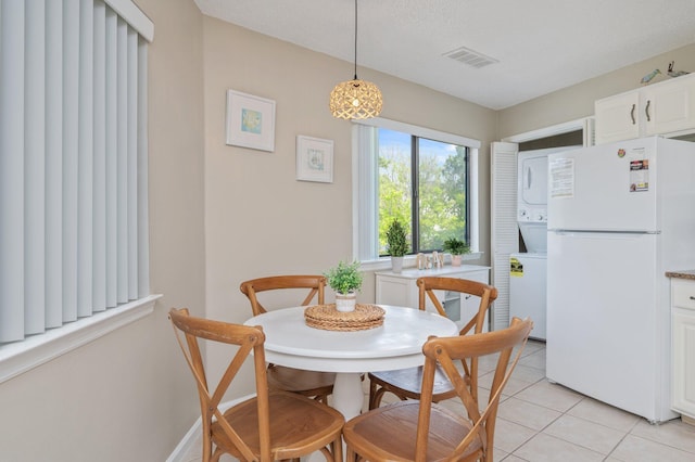 285 Payne St Unit 23B, Miramar Beach, FL 32550 - dining space featuring estacked washer and dryer and light tile patterned floors