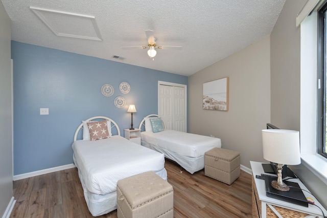 285 Payne St Unit 23B, Miramar Beach, FL 32550 - bedroom with attic access, wood finished floors, a closet, a textured ceiling, and baseboards