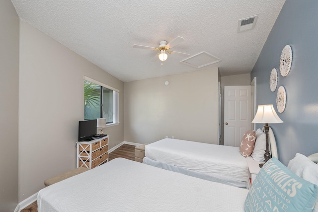 285 Payne St Unit 23B, Miramar Beach, FL 32550 - bedroom with attic access, wood finished floors, baseboards, a textured ceiling, and ceiling fan