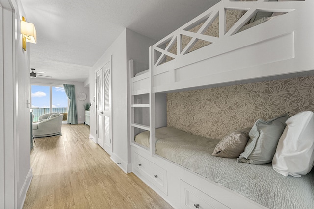 15928 Front Beach Rd # 32003, Panama City Beach, FL 32413 - unfurnished bedroom featuring light wood finished floors, access to exterior, baseboards, and a textured ceiling