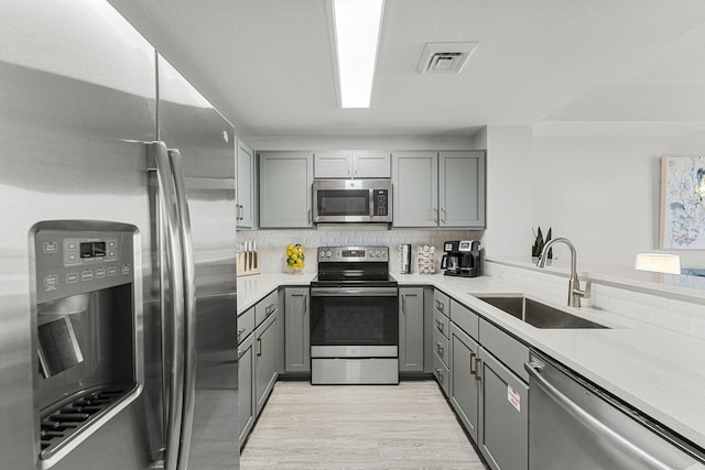 15928 Front Beach Rd # 32003, Panama City Beach, FL 32413 - kitchen with appliances with stainless steel finishes, gray cabinets, a sink, light wood-type flooring, and light countertops