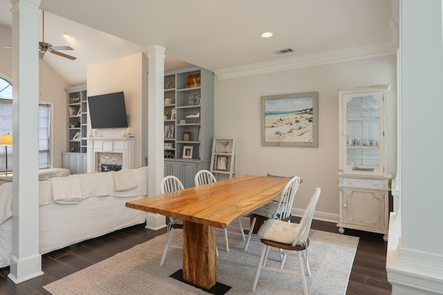 4467 Turnberry Pl, Niceville, FL 32578 - dining space with decorative columns, a fireplace, ornamental molding, a ceiling fan, and dark wood-style flooring