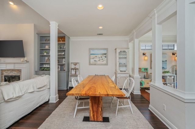 4467 Turnberry Pl, Niceville, FL 32578 - dining space with decorative columns, a fireplace, dark wood finished floors, crown molding, and baseboards