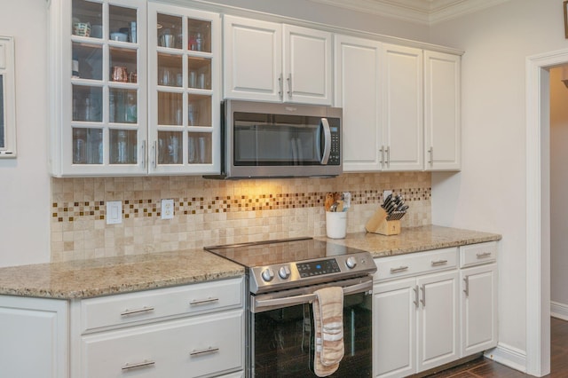 4467 Turnberry Pl, Niceville, FL 32578 - kitchen featuring appliances with stainless steel finishes, crown molding, glass insert cabinets, white cabinets, and tasteful backsplash