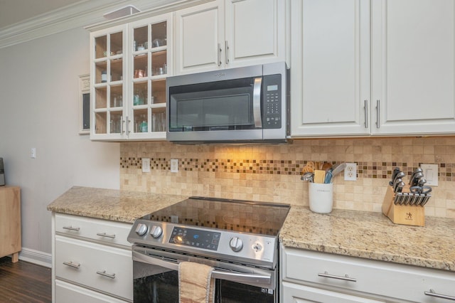 4467 Turnberry Pl, Niceville, FL 32578 - kitchen featuring appliances with stainless steel finishes, crown molding, glass insert cabinets, white cabinets, and tasteful backsplash