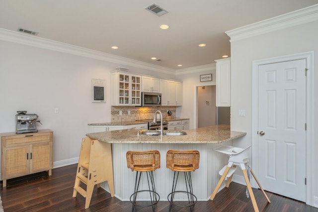 4467 Turnberry Pl, Niceville, FL 32578 - kitchen with stainless steel microwave, a sink, a peninsula, crown molding, and glass insert cabinets