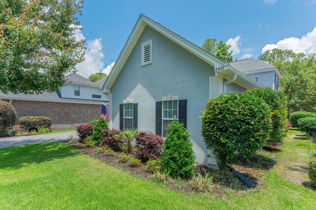 4467 Turnberry Pl, Niceville, FL 32578 - view of home's exterior featuring stucco siding and a lawn