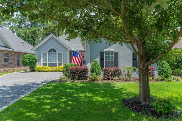 4467 Turnberry Pl, Niceville, FL 32578 - view of front of house with stucco siding, a front lawn, and roof with shingles