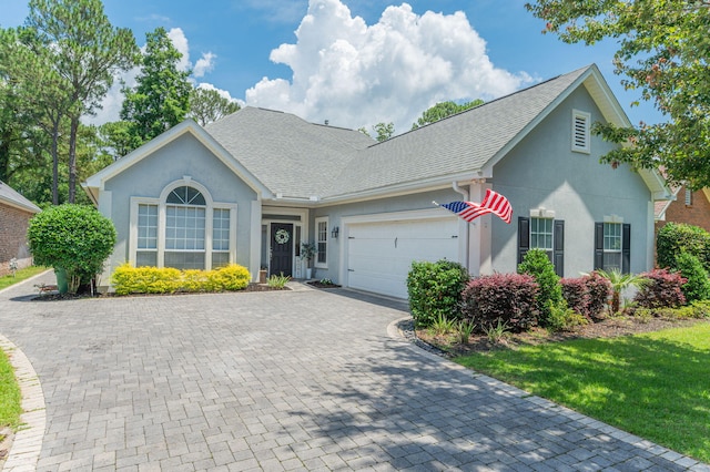 4467 Turnberry Pl, Niceville, FL 32578 - view of front of house featuring stucco siding, a garage, decorative driveway, and a shingled roof