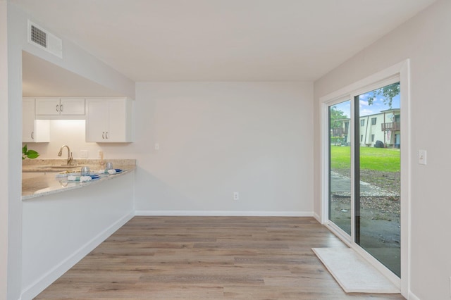 308 Miracle Strip Pkwy Unit 16B, Fort Walton Beach, FL 32548 - unfurnished dining area with light wood finished floors, baseboards, and a sink
