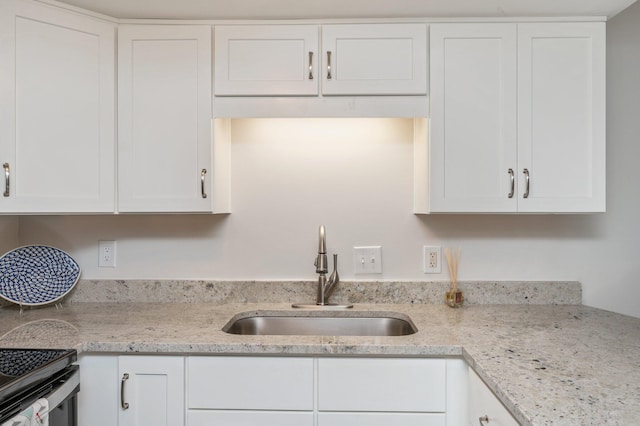 308 Miracle Strip Pkwy Unit 16B, Fort Walton Beach, FL 32548 - kitchen with a sink, white cabinets, and light stone countertops