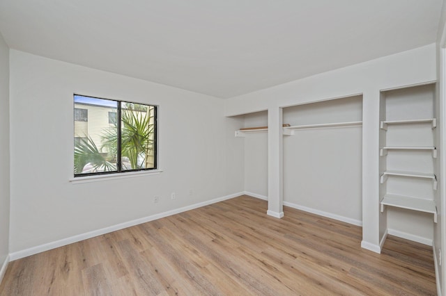 308 Miracle Strip Pkwy Unit 16B, Fort Walton Beach, FL 32548 - unfurnished bedroom with light wood-style flooring, two closets, and baseboards