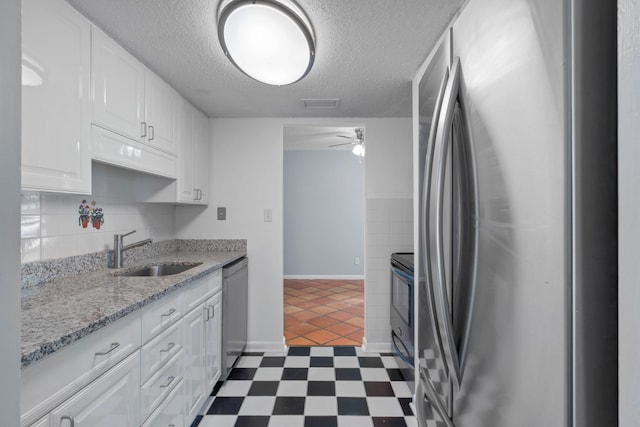 4 SW Miracle Strip Pkwy Unit 23, Fort Walton Beach, FL 32548 - kitchen with stainless steel appliances, a sink, white cabinetry, ceiling fan, and a textured ceiling