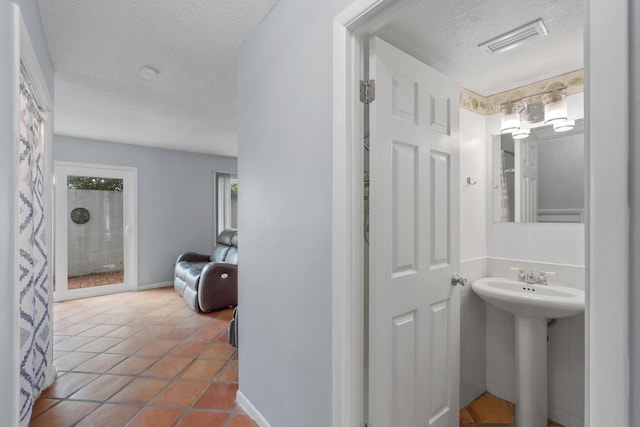 4 SW Miracle Strip Pkwy Unit 23, Fort Walton Beach, FL 32548 - full bathroom with a textured ceiling, tile patterned floors, a sink, and baseboards