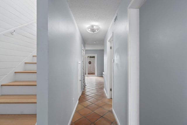 4 SW Miracle Strip Pkwy Unit 23, Fort Walton Beach, FL 32548 - hall featuring a textured ceiling, stairway, tile patterned floors, and baseboards