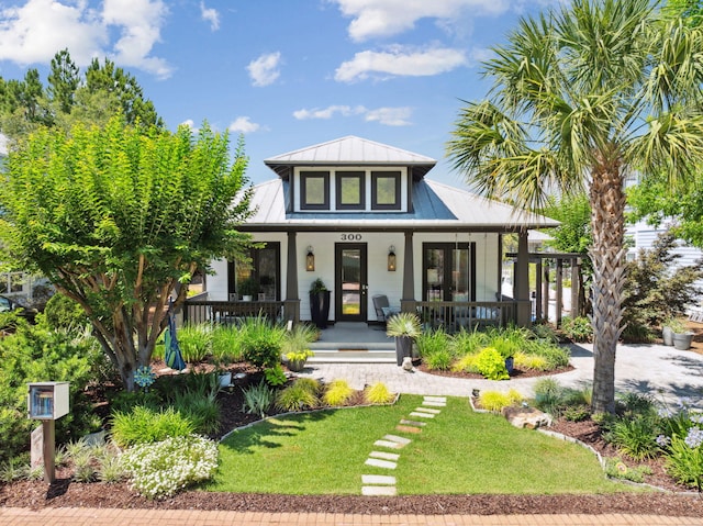 300 Cassine Garden Cir, Santa Rosa Beach, FL 32459 - view of front of home featuring covered porch, a metal roof, a front lawn, and a standing seam roof