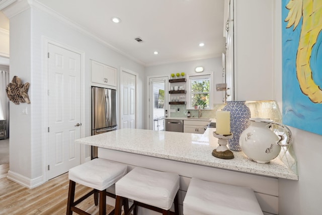 300 Cassine Garden Cir, Santa Rosa Beach, FL 32459 - kitchen with stainless steel appliances, ornamental molding, a peninsula, light stone counters, and decorative backsplash