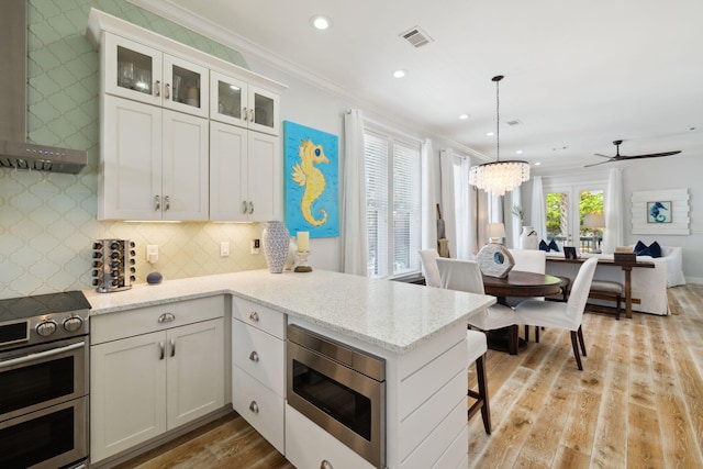 300 Cassine Garden Cir, Santa Rosa Beach, FL 32459 - kitchen featuring appliances with stainless steel finishes, light wood-style floors, range hood, recessed lighting, and white cabinets
