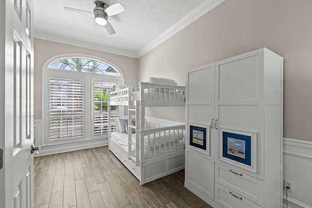 72 Tranquility Ln, Destin, FL 32541 - bedroom featuring crown molding, wood finished floors, a wainscoted wall, and a ceiling fan