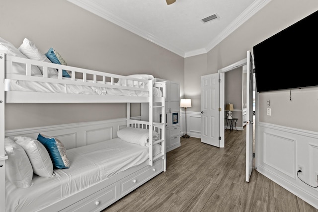 72 Tranquility Ln, Destin, FL 32541 - bedroom featuring ornamental molding, wainscoting, wood finished floors, and a decorative wall