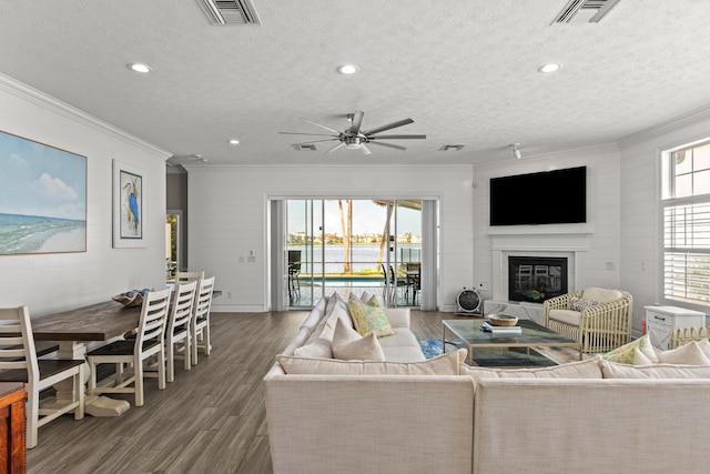 72 Tranquility Ln, Destin, FL 32541 - living area featuring wood finished floors, crown molding, ceiling fan, a glass covered fireplace, and a textured ceiling