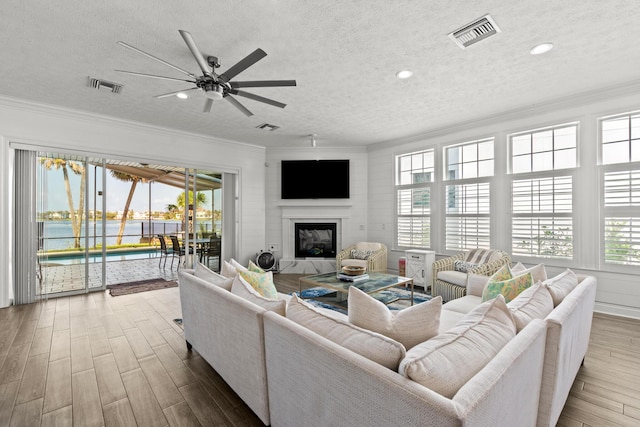 72 Tranquility Ln, Destin, FL 32541 - living room with ornamental molding, wood finished floors, healthy amount of natural light, a textured ceiling, and a ceiling fan