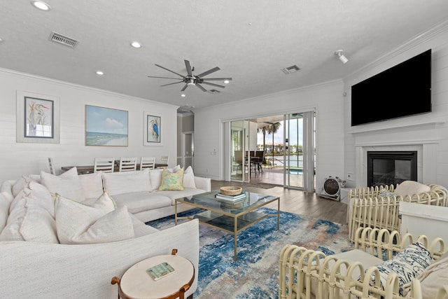 72 Tranquility Ln, Destin, FL 32541 - living room with wood finished floors, ornamental molding, a ceiling fan, a glass covered fireplace, and recessed lighting