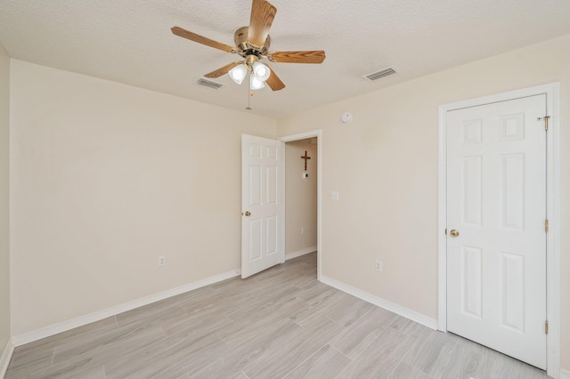642 Alysheba Dr, Crestview, FL 32539 - unfurnished bedroom featuring light wood finished floors, baseboards, ceiling fan, and a textured ceiling