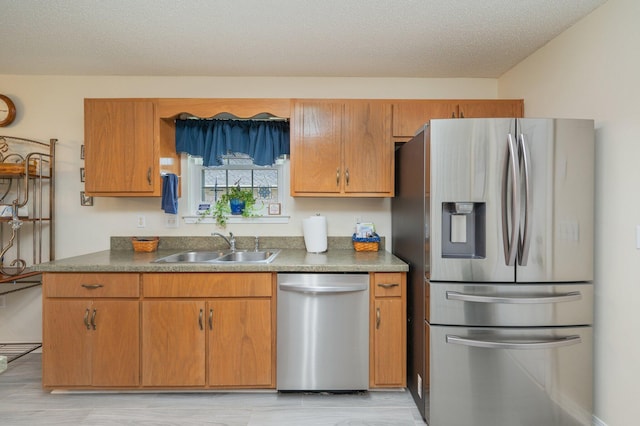 642 Alysheba Dr, Crestview, FL 32539 - kitchen featuring appliances with stainless steel finishes, a sink, dark countertops, and brown cabinetry