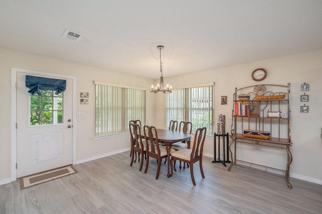 642 Alysheba Dr, Crestview, FL 32539 - dining area featuring a chandelier, light wood-type flooring, healthy amount of natural light, and a textured ceiling