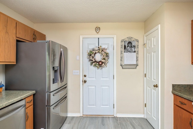 642 Alysheba Dr, Crestview, FL 32539 - kitchen featuring stainless steel appliances, light wood-style floors, brown cabinets, and baseboards