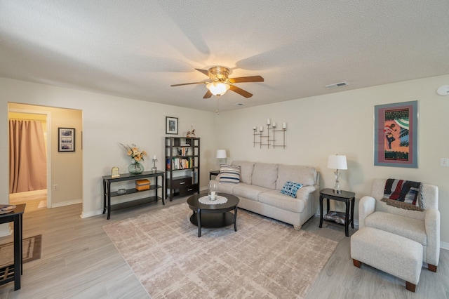 642 Alysheba Dr, Crestview, FL 32539 - living area with light wood-style floors, a ceiling fan, baseboards, and a textured ceiling