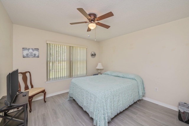642 Alysheba Dr, Crestview, FL 32539 - bedroom with light wood-style floors, baseboards, ceiling fan, and a textured ceiling