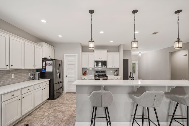 801 Playground Rd, Fort Walton Beach, FL 32547 - kitchen featuring stainless steel appliances, decorative backsplash, a kitchen bar, white cabinetry, and a sink